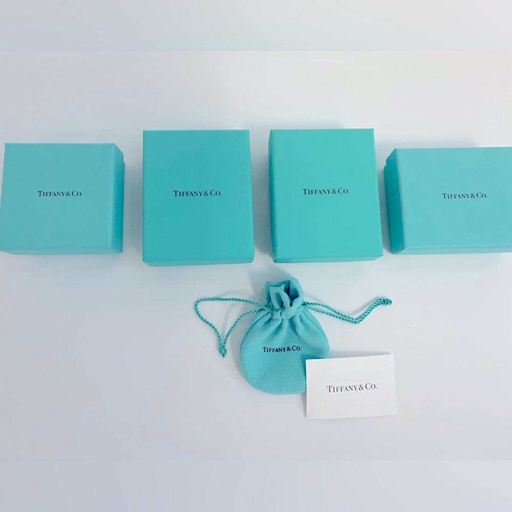 Four Tiffany jewelry boxes, pouch and card